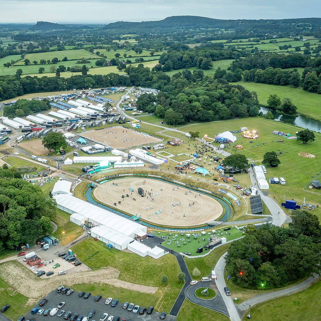 Aerial view of the Bolesworth International Horse Show showground, featuring arenas, parking, and surrounding countryside.
