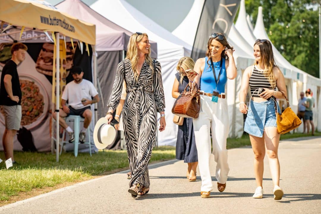 Ladies walking through the shopping area at Bolesworth International, enjoying the sunny outdoor market.