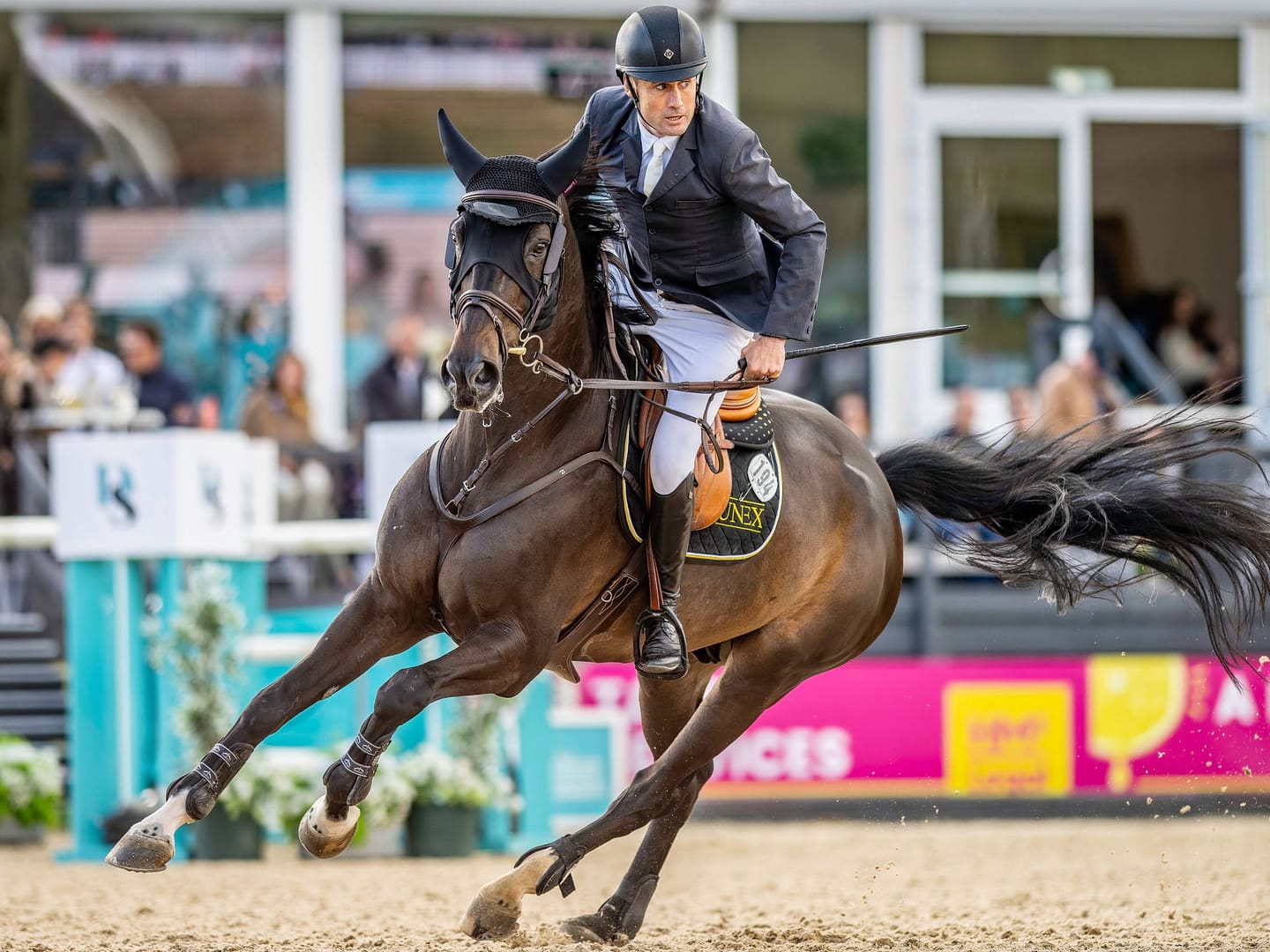 A rider and horse making a sharp turn during an equestrian competition, displaying skill and agility
