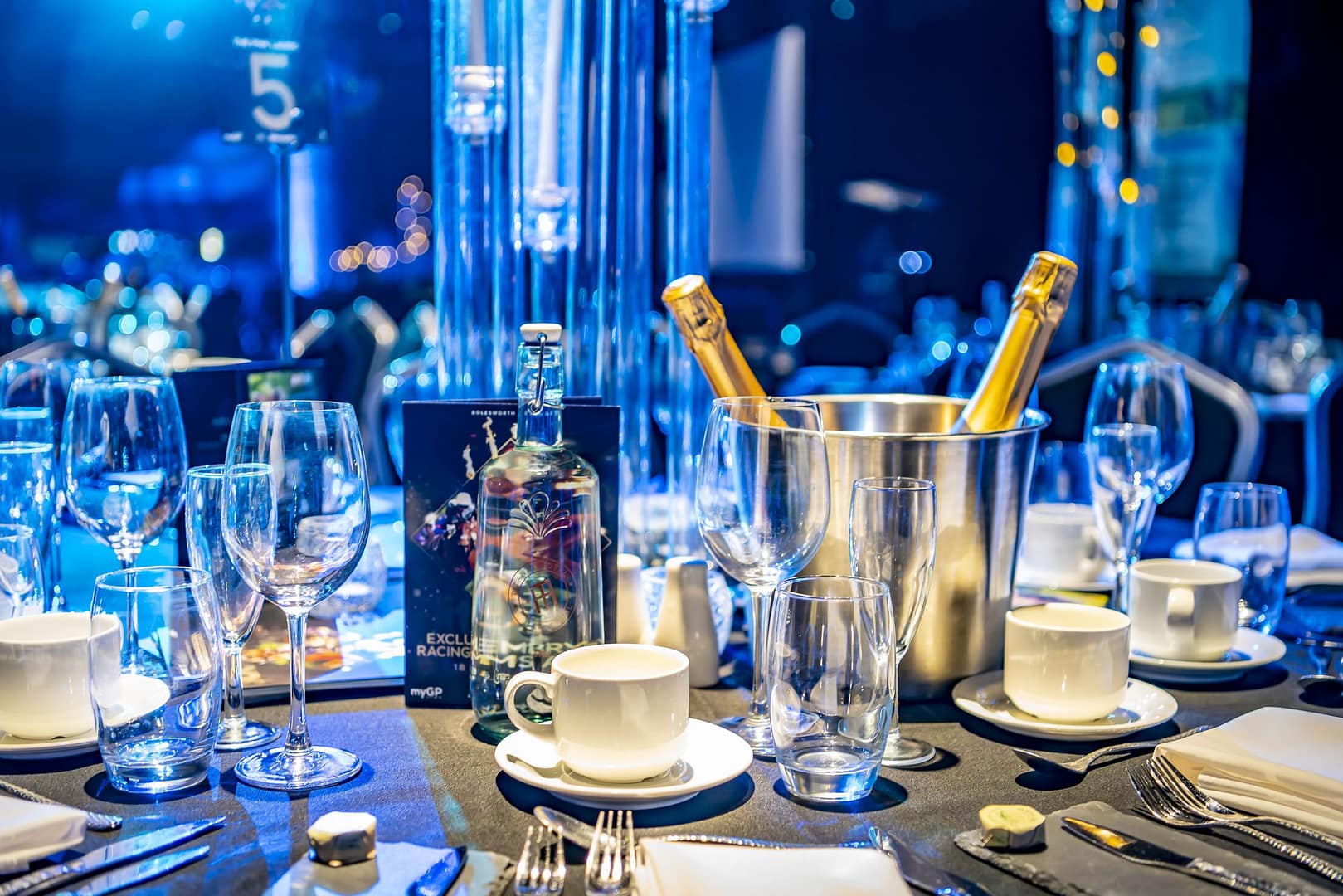A luxurious gala dinner setup at the Bolesworth Elite Auction, featuring a beautifully arranged table with champagne, fine glassware, and elegant décor.
