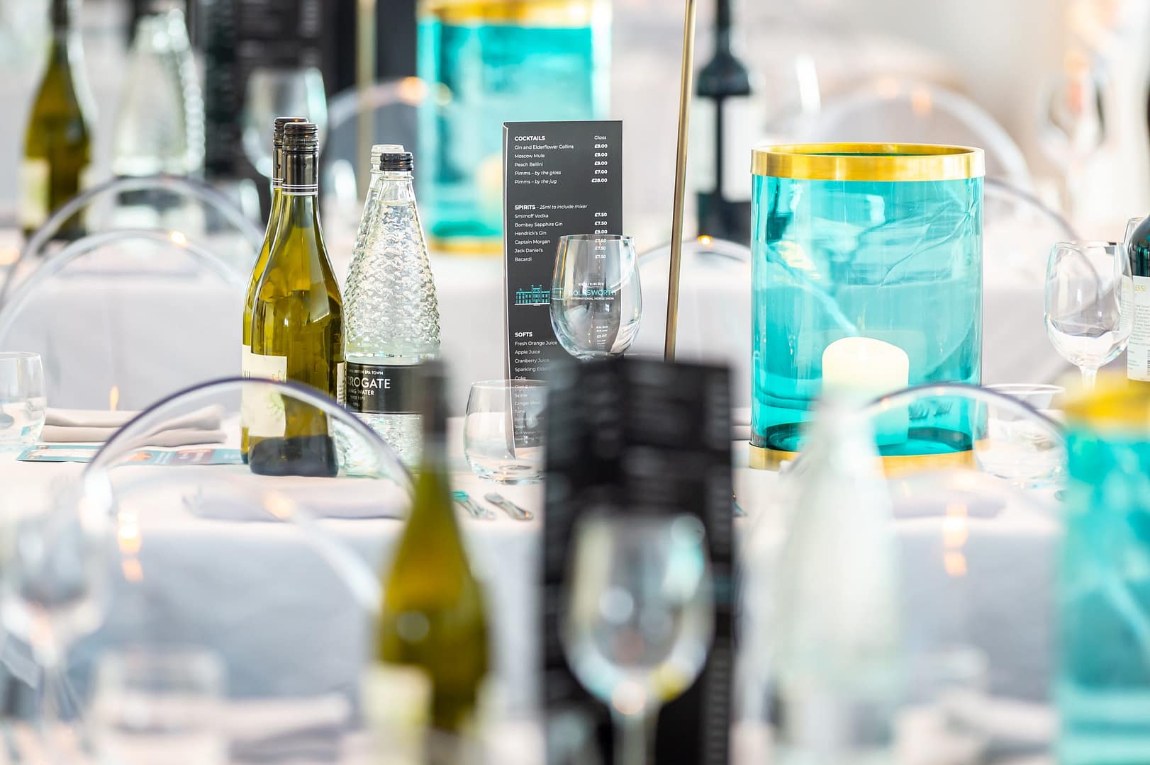 Hospitality set up containing table set up, glasses, wine and menus.