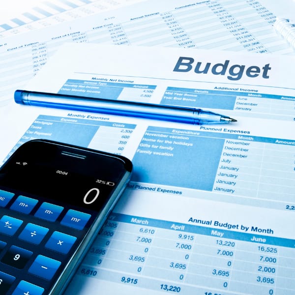 Budget planning document with a calculator and pen on a financial spreadsheet.