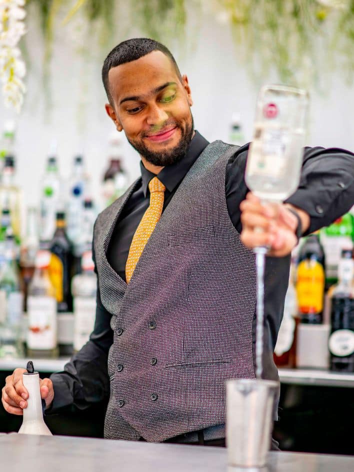 Bartender pouring a spirit into a class from a height