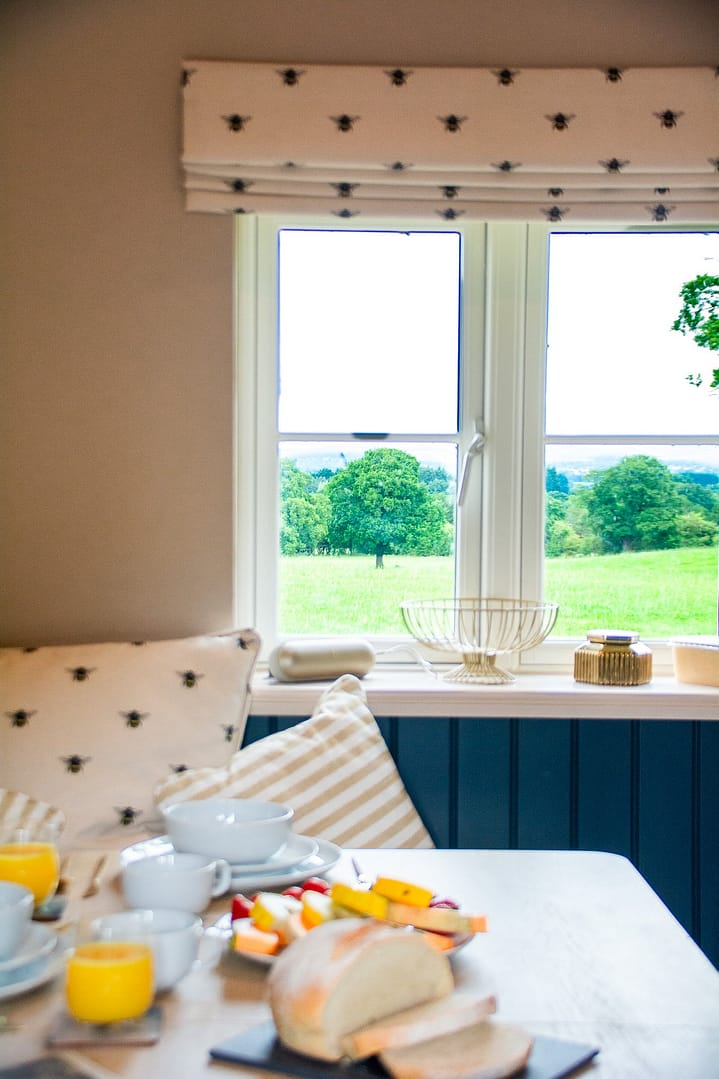 A window over looking a garden with trees with breakfast items on the table