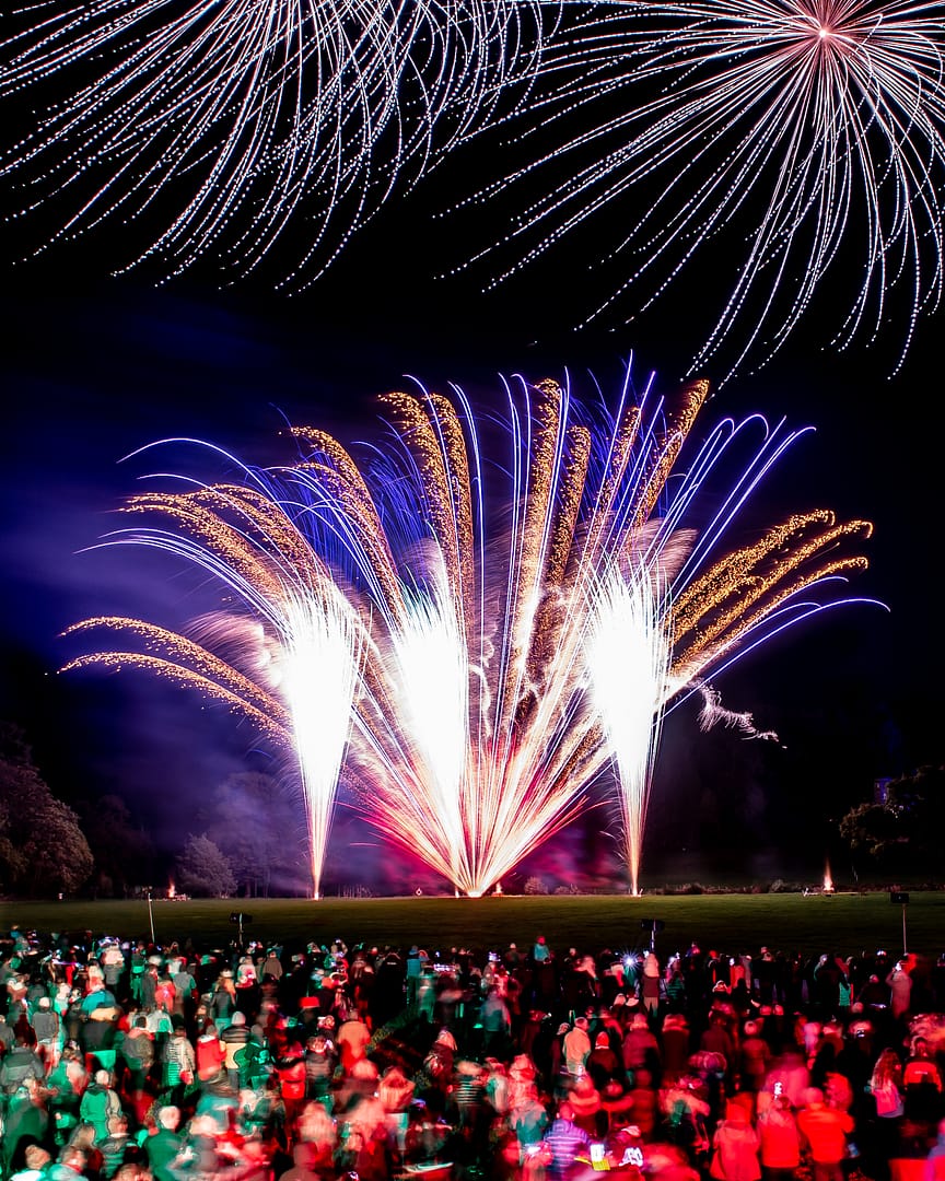 Bolesworth Estate firework display lighting up the night sky with colorful bursts, with busy crowds looking on in awe.